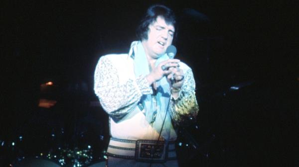 Elvis onstage in white suit with microphone