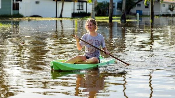 Halle Brooks kayaks down a street flooded by Hurricane Helene in the Shore Acres neighborhood Friday, Sept. 27, 2024, in St. Petersburg, Fla. (AP Photo/Mike Carlson)